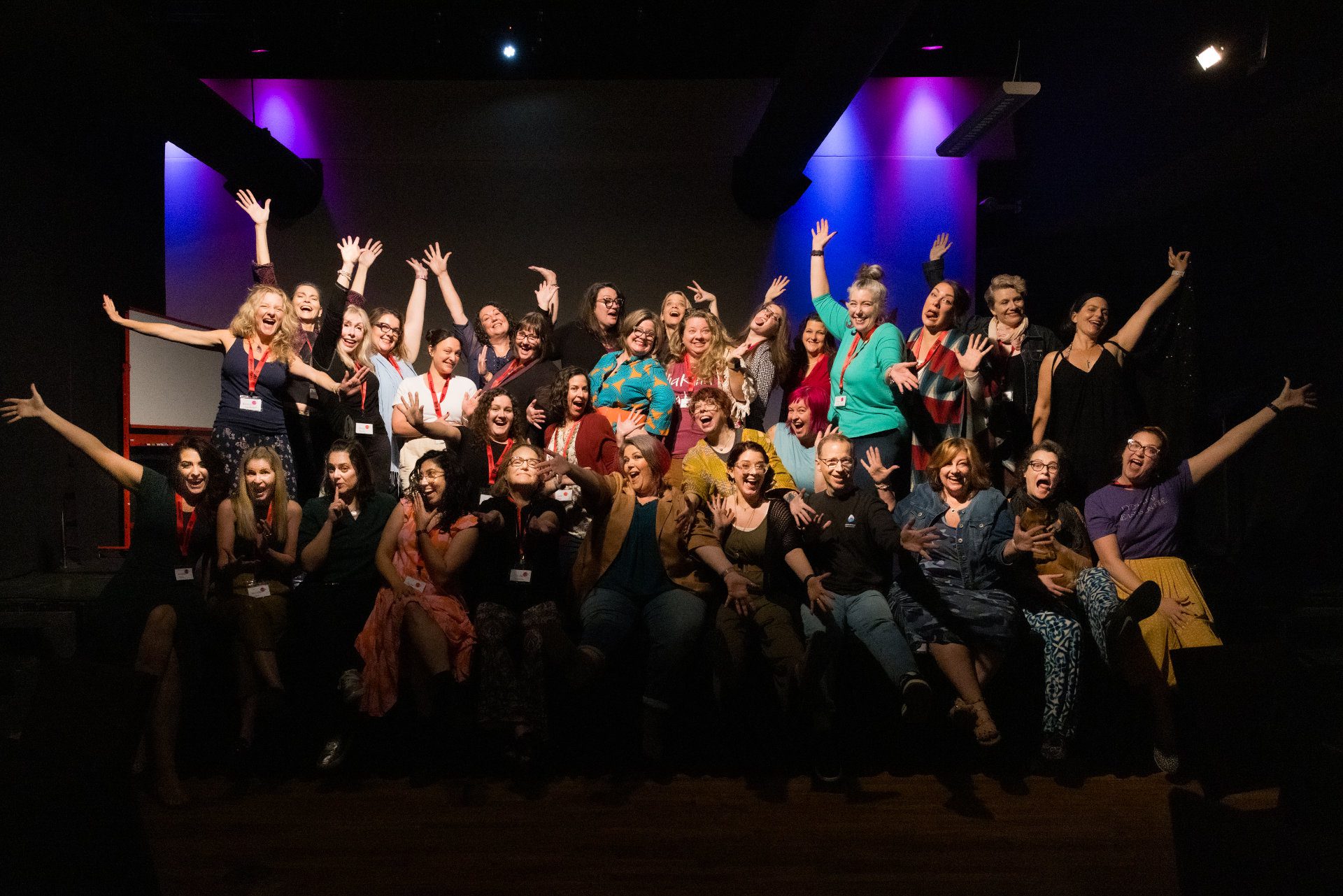 All the attendees of SECOLive 2023 on stage with hands out in the air.